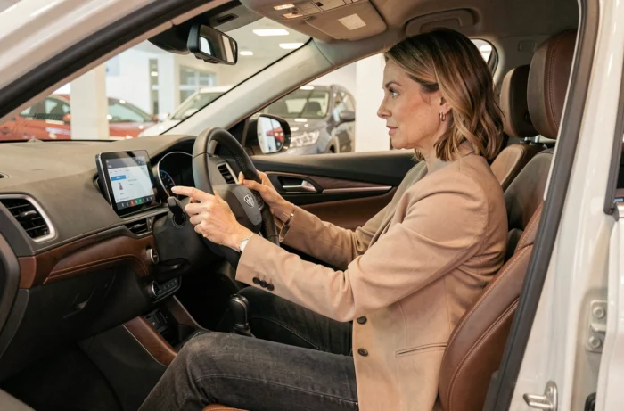 Femme inspectant l'intérieur et les commandes d'un SUV compact lors d'un essai en concession